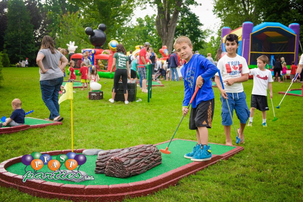 Smiling boy plays mini golf