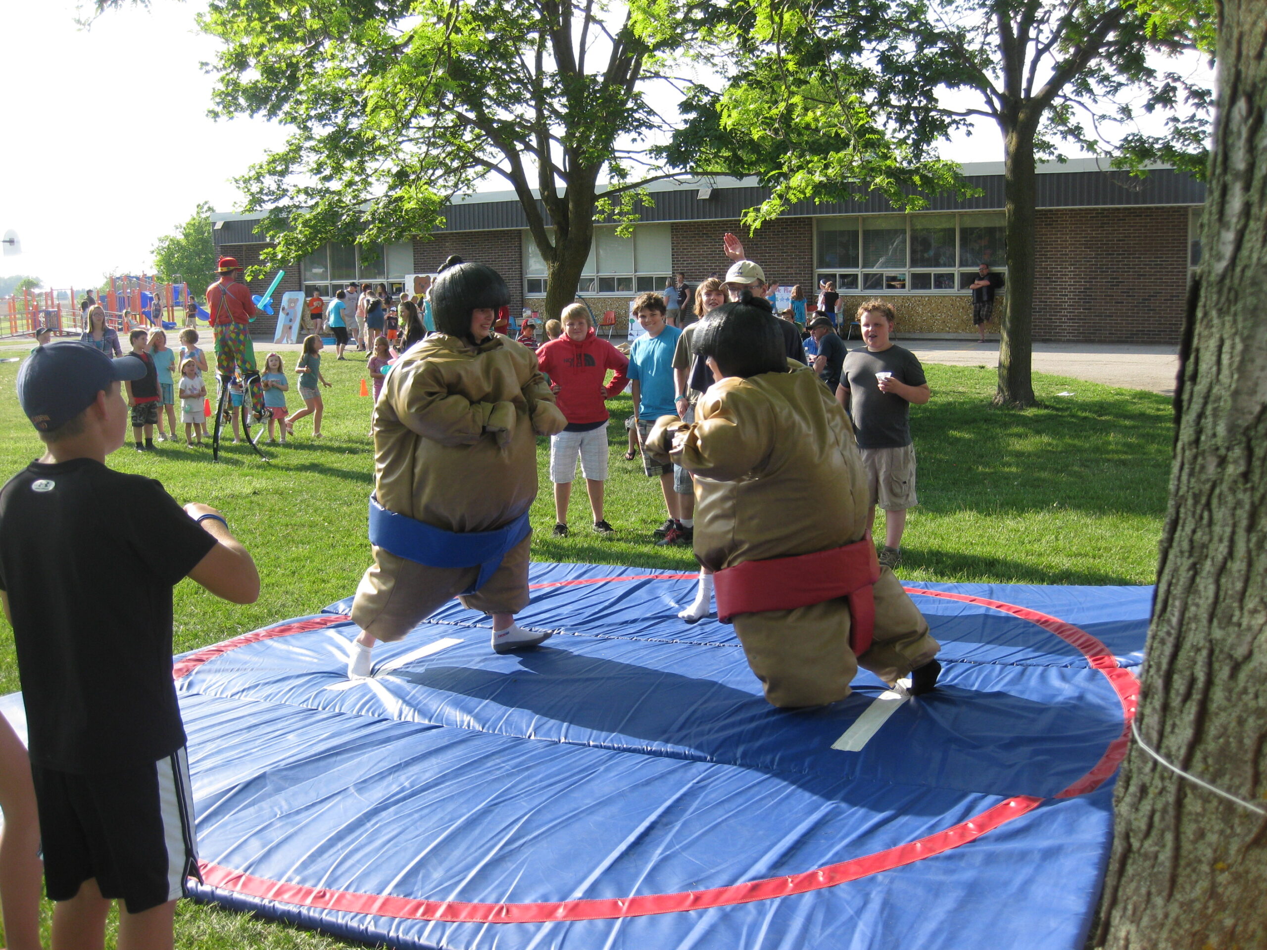 Two sumo wrestles in sumo suits competing at outdoor event