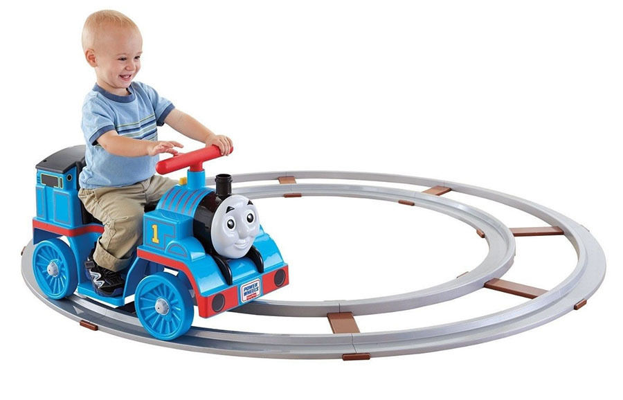 Smiling boy riding Thomas the train rider